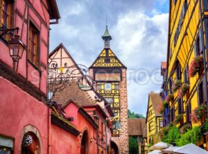 Colorful houses on a central street in Riquewihr, village on wine route in Alsace, France