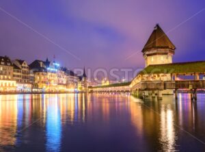 Lucerne, Switzerland, night view over the Reuss river to the wooden Chapel bridge and Water tower