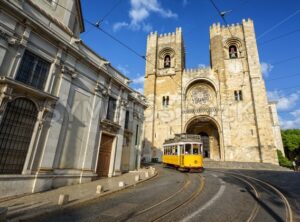 Old tram in front of cathedral in Lisbon, Portugal