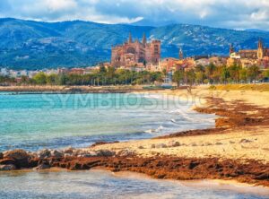 Sand beach in Palma de Mallorca, gothic cathedral in background, Spain