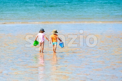 Two children playing on a sand beach at sea Stock Photo