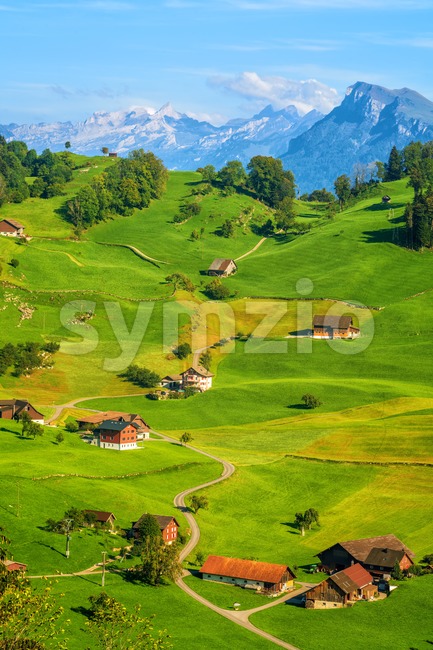 Idyllic green meadows and Alps mountains landscape, Switzerland Stock Photo